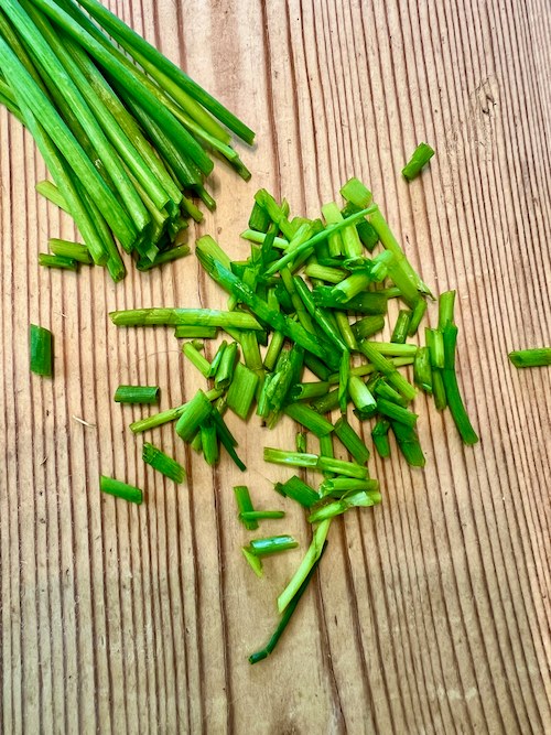 photo of some chives on a chopping board