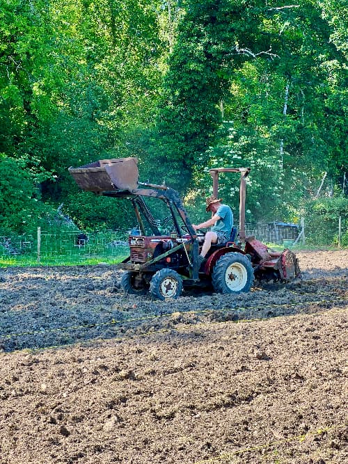 photo of an old red Yanmar tractor with a tiller on the back