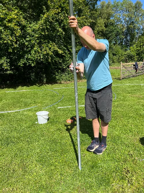 photo of a man degreasing a polytunnel frame pipe with soapy water
