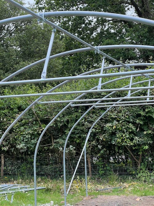 photo of hoop house frame with struts between the ridge pole and crop bars